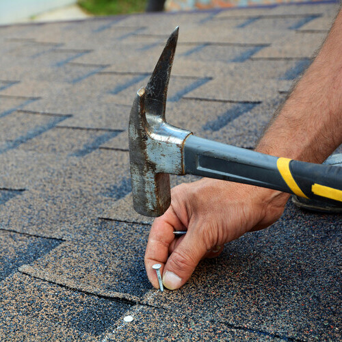 closeup of shingles being nailed down