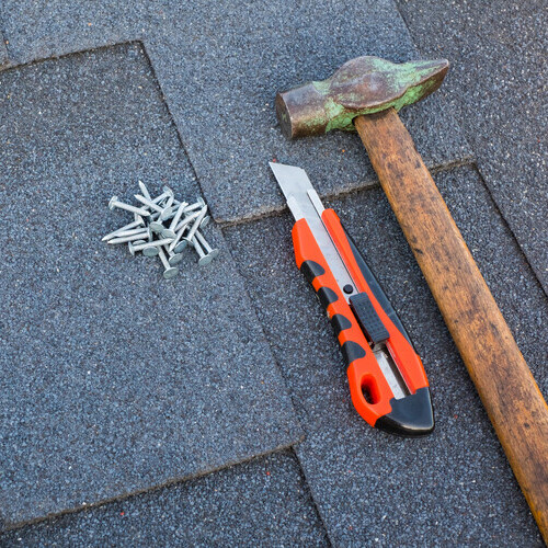 closeup of tools on a shingle roof